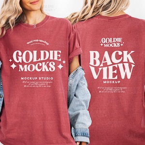 以下が含まれることがあります： 前面に「GOLDIE MOCKS」、背面に「BACK VIEW MOCKUP」と書かれた赤いTシャツ。 このシャツはPOD製品のモックアップで、ブランド名とスタジオ情報が白で表示されています。