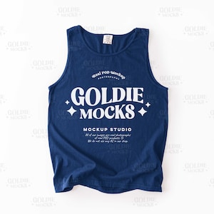 May include: Navy blue tank top with the text "GOLDIE MOCKS" in white, along with additional text. The tank top is a mockup, designed for showcasing designs. The tank top is a sleeveless shirt.