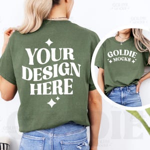 May include: A green t-shirt mockup with the text "YOUR DESIGN HERE" printed on the back. The shirt is being modeled by a person wearing blue jeans.