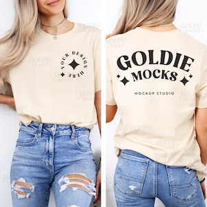 以下が含まれることがあります： 前面に「Your Design Here」と星が書かれた黒いデザインが施されたベージュのTシャツ。Tシャツの背面には、「Goldie Mocks」と星と「Mockup Studio」の文字が書かれた黒いデザインが施されています。