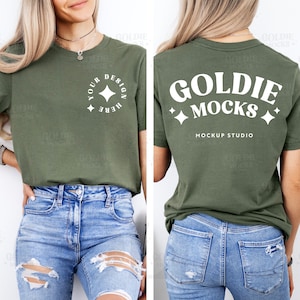 以下が含まれることがあります： 短い袖の緑色のTシャツで、前面には「Your Design Here」という白いデザインが星形の円の中に書かれています。Tシャツの背面には、「Goldie Mocks」という白いデザインが星形と「Mockup Studio」というテキストと共に書かれています。
