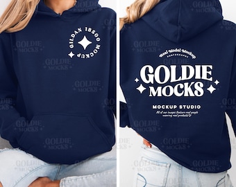 May include: A navy blue hoodie with a white logo that says "Goldie Mocks" and "Mockup Studio". The hoodie is being worn by a person with blonde hair and blue jeans.