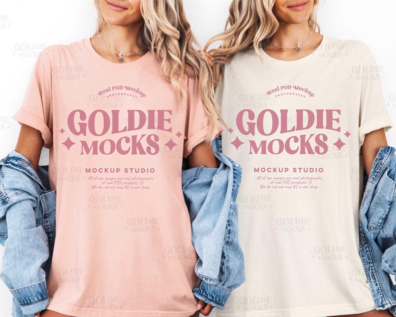 May include: Two women wearing t-shirts with the text "GOLDIE MOCKS" in pink. The shirts are different colors, one is light pink and the other is off-white. Both shirts have the text "MOCKUP STUDIO" below the main text.