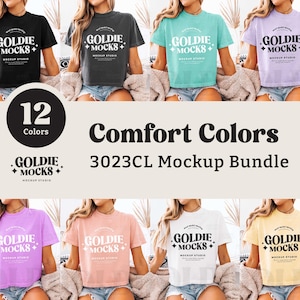 May include: A mockup bundle of 12 different coloured t-shirts featuring the text "GOLDIE + MOCKS + MOCKUP STUDIO" in a retro font. The t-shirts are all cropped and have a relaxed fit.
