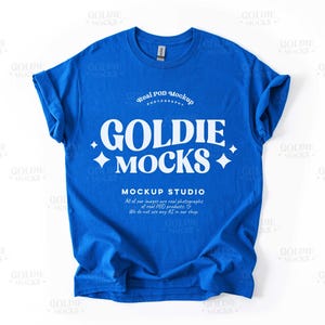 May include: A bright blue t-shirt mockup with the text "Goldie Mocks" and "Real POD Mockup Photography" in white. The text "Mockup Studio" is also included with the tagline "All of our images are real photographs of real POD products. We do not use any AI in our shop."