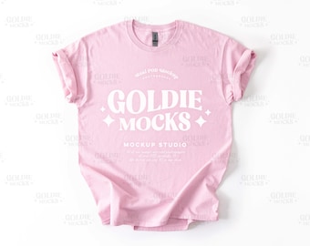 Könnte beinhalten: Ein pinkfarbenes T-Shirt-Mockup mit dem Text "Goldie Mocks" und "Mockup Studio" auf der Vorderseite.