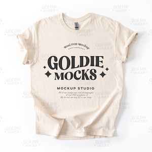 Könnte beinhalten: Ein beigefarbenes T-Shirt-Mockup mit dem Text "Goldie Mocks" und "Mockup Studio" in Schwarz. Der Text lautet "Alle unsere Bilder sind echte Fotos von echten POD-Produkten. Wir verwenden keine KI in unserem Shop."