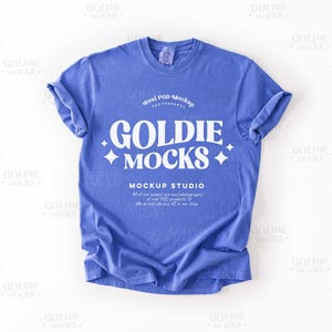 May include: A blue t-shirt mockup with the text "Real POD Mockup" and "Goldie Mocks" in white. The text "Mockup Studio" is also included in white.