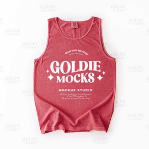 May include: A red tank top featuring the white text "GOLDIE MOCKS" and "MOCKUP STUDIO". The top has a scoop neck and is a solid colour. The image is a mockup.