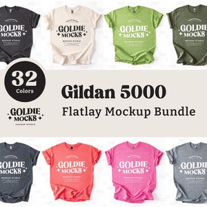 Può includere: Un set di mockup di t-shirt Gildan 5000 in flatlay, composto da 32 t-shirt di diversi colori. Le t-shirt sono disposte su uno sfondo bianco e presentano il testo "Goldie Mocks" sul davanti.