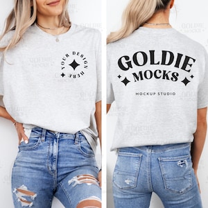 May include: A gray t-shirt mockup with a black design on the front that says "YOUR DESIGN HERE" with a star in a circle. The back of the shirt has a black design that says "GOLDIE MOCKS MOCKUP STUDIO" with stars on either side of the text.