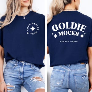 May include: A navy blue t-shirt with a white design on the front that says "Your Design Here" with a star in a circle. The back of the shirt has a white design that says "Goldie Mocks" with stars and the text "Mockup Studio".