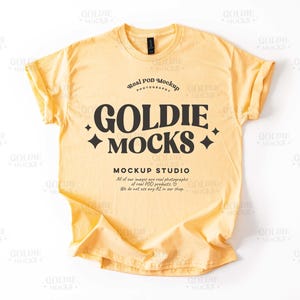May include: A yellow t-shirt mockup featuring the text "Goldie Mocks" and "Mockup Studio" in black. The text "Real POD Mockup Photography" is also included in black.