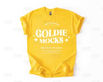 Könnte beinhalten: Ein gelbes T-Shirt mit dem Text "Goldie Mocks" und "Mockup Studio" auf der Vorderseite. Das Shirt ist ein Mockup für ein T-Shirt-Design.
