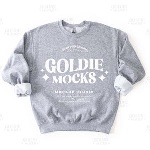 May include: A grey sweatshirt with the text "Real POD Mockup Goldie MOCKs Mockup Studio" printed on the front.