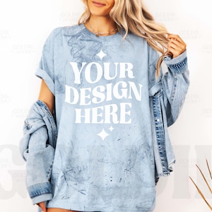 Puede incluir: Una camiseta azul claro con un aspecto desgastado y el texto "YOUR DESIGN HERE" impreso en blanco.