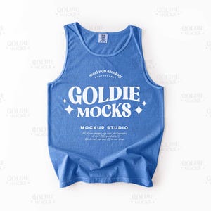 May include: A blue tank top with the text "GOLDIE MOCKS" in white, along with the words "MOCKUP STUDIO" and other text. The tank top is a solid blue color and has a tag at the top.
