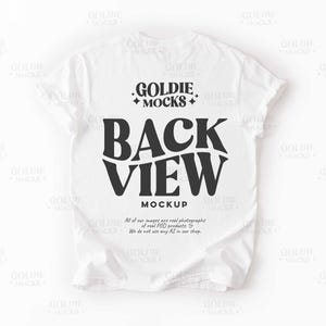 Puede incluir: Maqueta de camiseta blanca con el texto "BACK VIEW" en letras negras. El texto "GOLDIE MOCKS" también es visible en la parte superior central de la camiseta.