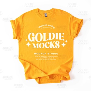 May include: A yellow t-shirt with the text "Goldie Mocks" and "Real POD Mockup Studio" printed on it.