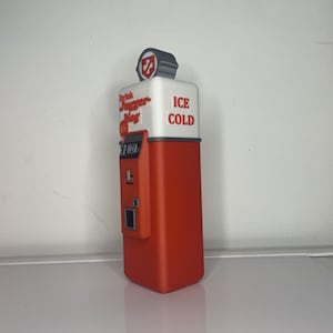 May include: Red and white vintage-style drink dispenser with the text "Drink Jugger-Nog" and "ICE COLD".