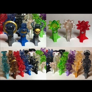 May include: A collection of colorful plastic figurines on stands. The figurines are in various shapes and colors, including green, red, blue, and purple. The stands are all the same shape, but are in different colors.