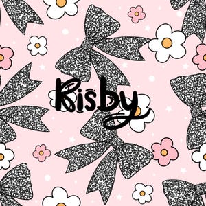 Può includere: Un motivo ripetuto su sfondo rosa con grandi fiocchi strutturati in bianco e nero, fiori bianchi e rosa e piccole stelle bianche. La parola "Kisby" è scritta in nero.