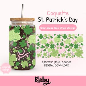 May include: A glass can with a wooden lid and a silver straw, featuring a St. Patrick's Day design. The design includes green shamrocks, light green floral accents, and a pink ribbon on a dark brown background. The text "Coquette St. Patrick's Day" is displayed.