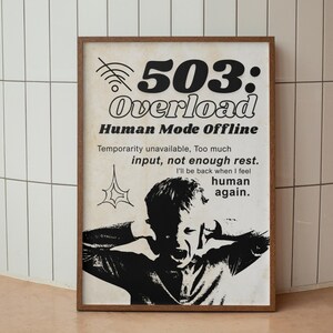 May include: A framed poster with a distressed aesthetic. The poster features the text "503: Overload" and "Human Mode Offline." A black and white illustration of a person covering their ears is below the text. The poster's message is about information overload.