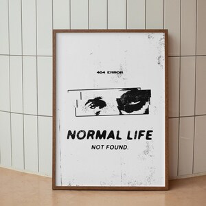 May include: A framed art print with a white background and a distressed aesthetic. The print features a graphic of two eyes, the text "404 ERROR", and the words "NORMAL LIFE NOT FOUND" in bold, black font.