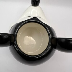 Peut inclure: Mug en c&eacute;ramique noir et blanc en forme de t&ecirc;te de Mickey Mouse. La tasse a un int&eacute;rieur noir et un bord blanc.