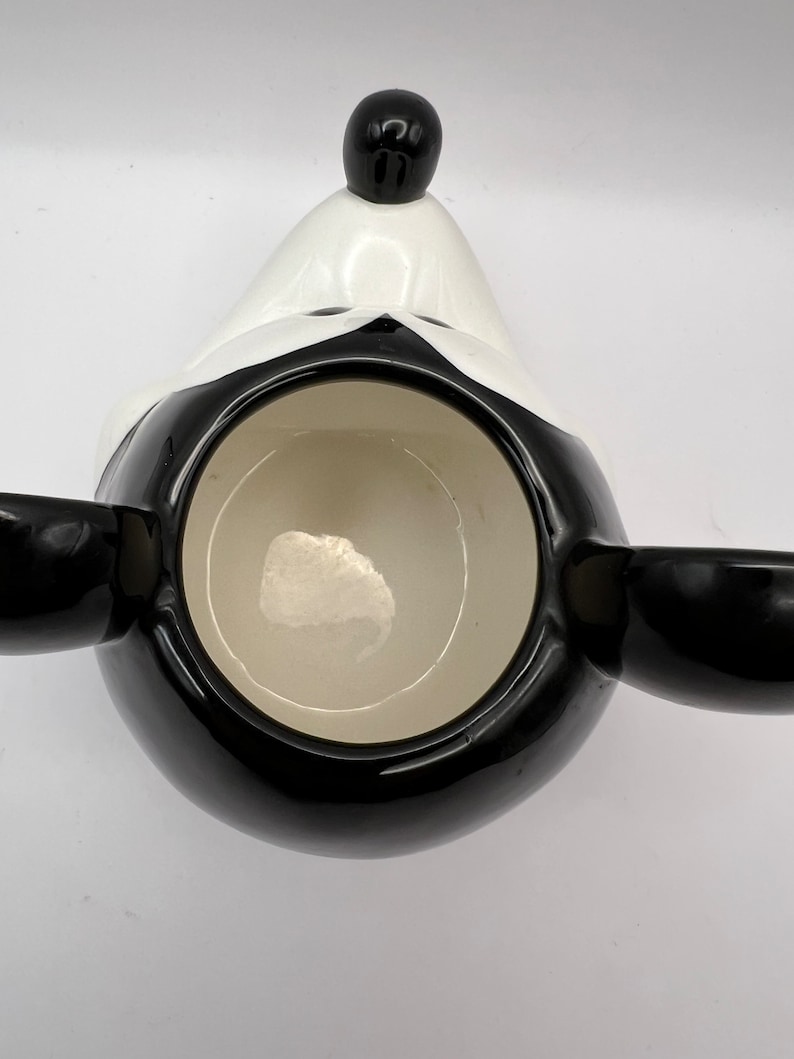 Peut inclure: Mug en c&eacute;ramique noir et blanc en forme de t&ecirc;te de Mickey Mouse. La tasse a un int&eacute;rieur noir et un bord blanc.