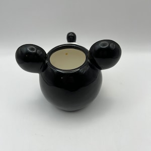 Peut inclure: Pot en c&eacute;ramique noire avec deux oreilles arrondies sur les c&ocirc;t&eacute;s. Le pot a un int&eacute;rieur blanc.