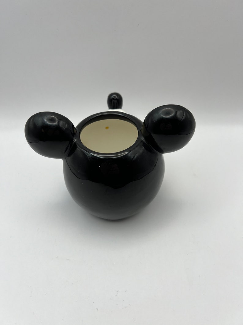 Peut inclure: Pot en c&eacute;ramique noire avec deux oreilles arrondies sur les c&ocirc;t&eacute;s. Le pot a un int&eacute;rieur blanc.