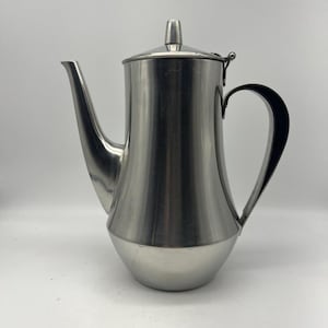 May include: A silver stainless steel coffee pot with a black handle and a hinged lid.