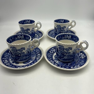 May include: Set of four blue and white porcelain teacups and saucers with a floral and landscape design.