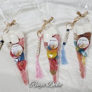 May include: Three clear plastic cones filled with colorful candies, marshmallows, and a small round sticker. Each cone has a personalized wooden bead keychain with a name, such as "Fatih", "Ferihra", and "Yunus".