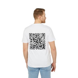Puede incluir: Camiseta blanca con un gran código QR negro impreso en la espalda. La camiseta de manga corta tiene cuello redondo. La persona lleva vaqueros azules.