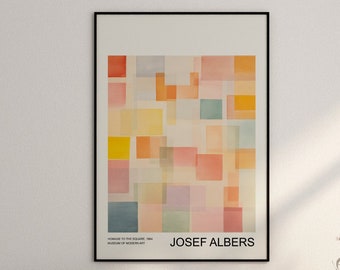 May include: A framed abstract art print with a geometric design of colorful squares. The print is titled "Hommage to the Square" by Josef Albers. The print is hanging on a white wall above a light beige sofa with pillows.