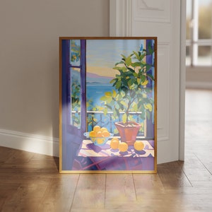 Puede incluir: Una pintura enmarcada que representa una naturaleza muerta con limones y un limonero en maceta. La pintura muestra una ventana con vista a un mar azul y una cadena montañosa en la distancia. Los limones están dispuestos sobre una mesa con un mantel morado.