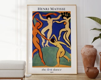 May include: A framed poster of Henri Matisse's "The Dance" painting. The painting depicts five figures dancing in a circle against a blue background. The figures are painted in shades of orange, yellow, and white.