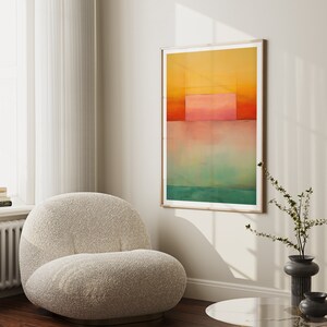 Peut inclure: Impression d'art abstrait avec un sch&eacute;ma de couleurs jaune, rose et vert. L'impression est encadr&eacute;e dans un cadre en bois clair et est accroch&eacute;e &agrave; un mur blanc.