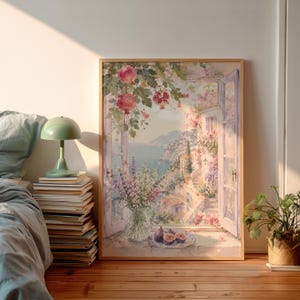 Könnte beinhalten: Ein gerahmter Aquarelldruck zeigt ein offenes Fenster mit Blick auf ein italienisches Küstendorf. Das Kunstwerk zeigt Blumen, darunter Rosen und Lavendel, mit einer Vase mit Blumen und Feigen auf einem Teller im Vordergrund.