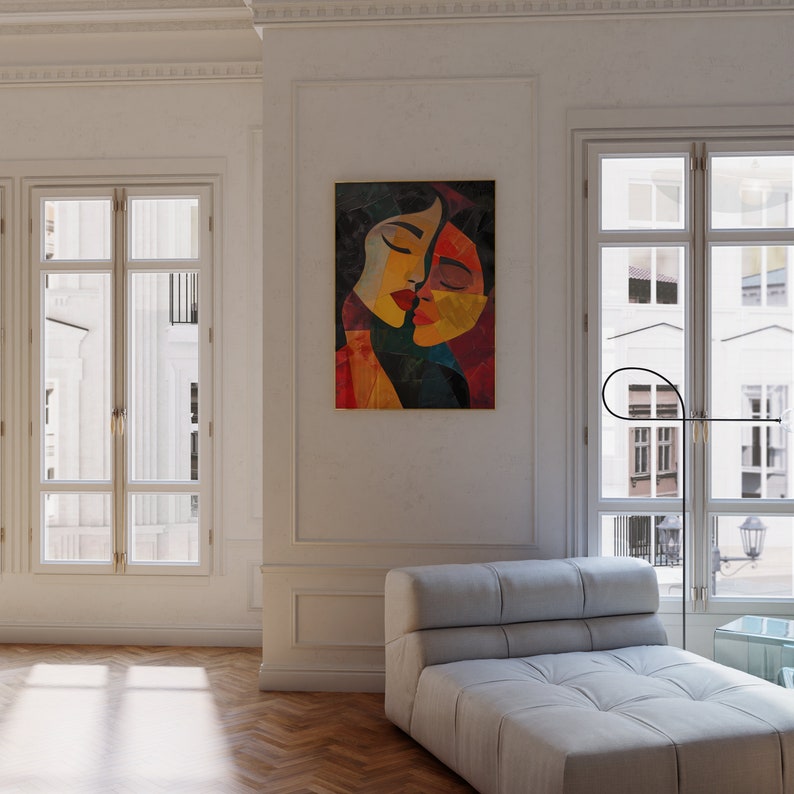 May include: A white sofa with a tufted design sits in a room with white walls and large windows. A colourful abstract painting of two faces hangs on the wall behind the sofa.
