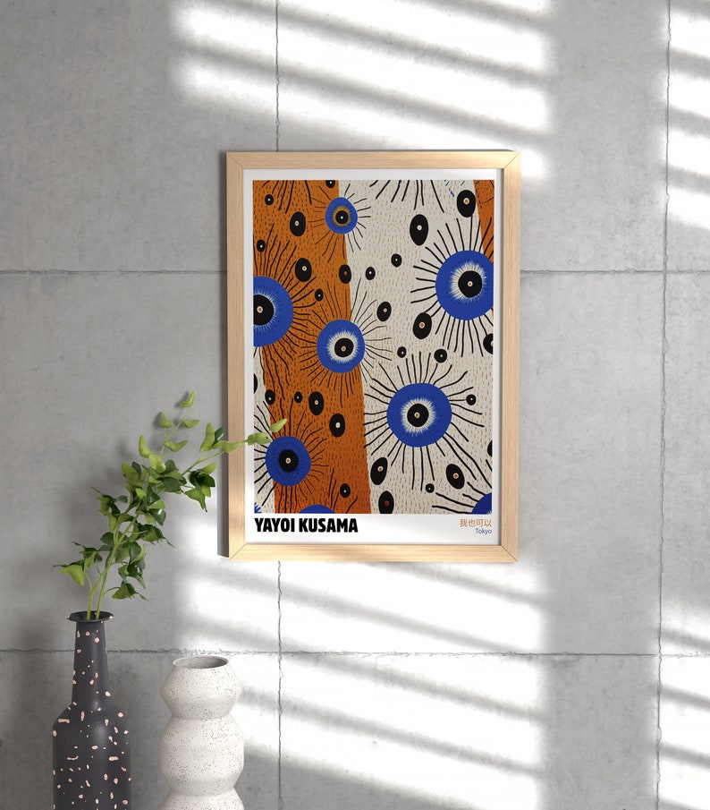 May include: A framed print of a colorful abstract art piece by Yayoi Kusama. The artwork features a pattern of blue eyes with black outlines and white and orange backgrounds. The print is titled "Beautiful" and is signed "Yayoi Kusama, Tokyo."