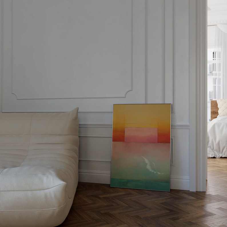 Peut inclure: Une peinture abstraite encadr&eacute;e avec un sch&eacute;ma de couleurs jaune, orange, rose et bleu. La peinture est accroch&eacute;e &agrave; un mur blanc dans une pi&egrave;ce avec un canap&eacute; blanc.