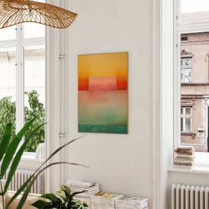 Peut inclure: Peinture abstraite aux couleurs jaune, orange, rose et bleu. La peinture est encadr&eacute;e d'un cadre fin en or et est accroch&eacute;e &agrave; un mur blanc.