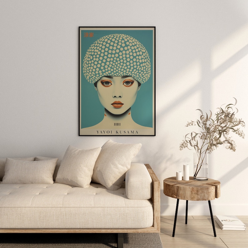 May include: A framed art print depicting a woman with a polka-dot head covering against a teal backdrop. The print includes the name "YAYOI KUSAMA". The artwork is displayed above a beige sofa in a living room setting.