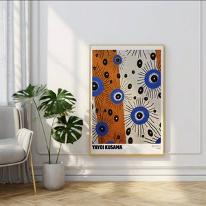 May include: A framed print of an abstract art piece featuring a white background with blue and orange circles and dots. The print is titled "Yayoi Kusama, Tokyo".