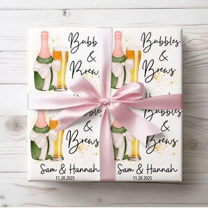 May include: White gift wrap featuring champagne bottles, beer glasses, and the text "Bubbles & Brews." The design includes a pink bow and the names "Sam & Hannah" with the date "11.20.2025."