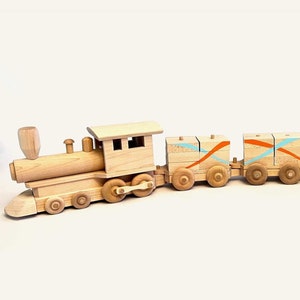 May include: A wooden toy train with a locomotive and five cars. The cars are painted with orange and blue stripes. The train is made of natural wood and has a rustic look.